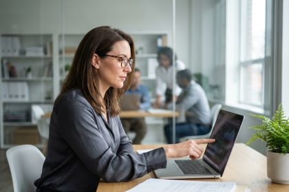Femme professionnelle concentrée au bureau avec ordinateur