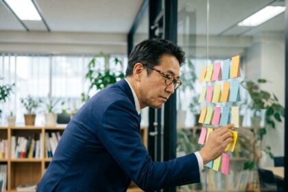 Homme d'affaires japonais arrangeant des notes colorées